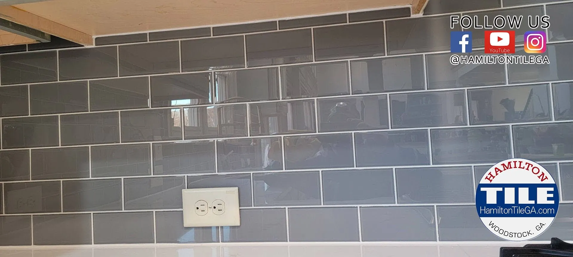 Gray subway tile kitchen backsplash with white grout, outlet, and Hamilton Tile branding overlay